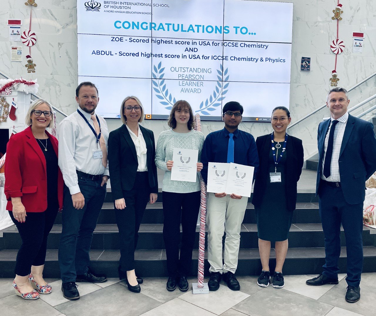 Zoe Atherton, fourth from left, and Abdul Rehman Maulana, both 10th graders at the British International School of Houston, display their awards for academic achievement.